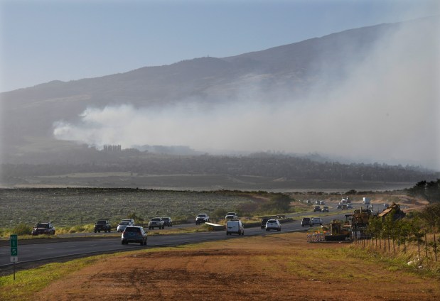 Smoke blows across the slope of Haleakala volcano on Maui, Hawaii, as a fire burns in Maui's upcountry region on Tuesday, Aug. 8. 2023. Several Hawaii communities were forced to evacuate from wildfires that destroyed at least two homes as of Tuesday as a dry season mixed with strong wind gusts made for dangerous fire conditions. (Matthew Thayer/The Maui News via AP)