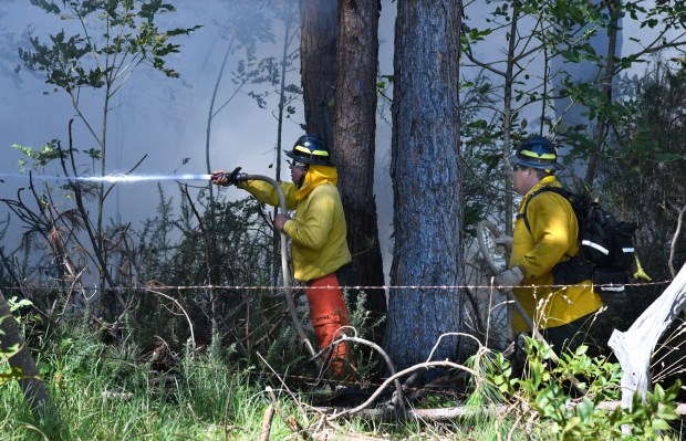 Members of a Hawaii Department of Land and Natural Resources wildland firefighting crew on Maui battle a fire in Kula, Hawaii, on Tuesday, Aug. 8, 2023. Several Hawaii communities were forced to evacuate from wildfires that destroyed at least two homes as of Tuesday as a dry season mixed with strong wind gusts made for dangerous fire conditions. (Matthew Thayer/The Maui News via AP)
