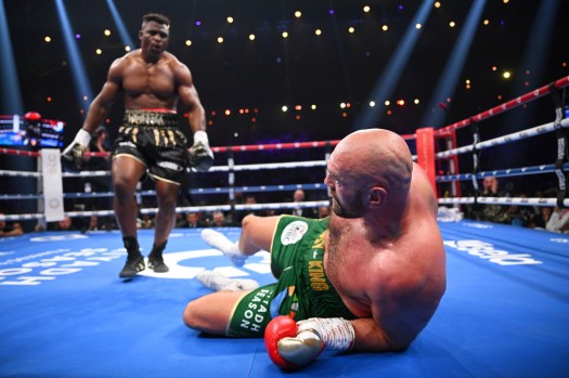 Heavyweight boxing champion survives a knockdown and scores a 94-95, 96-93, 95-94 split decision in a non-title fight against the former UFC champ.