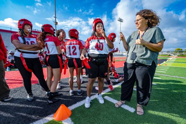 Jennifer Reed (40), a junior quarterback on Lakewood High's girls flag football team who is hearing impaired, looks to Karen Sexton, right, a sign language interpreter, before a game against Jordan High on Wednesday, Oct. 25, 2023, in Lakewood. (Photo by Mark Rightmire, Orange County Register/SCNG)
