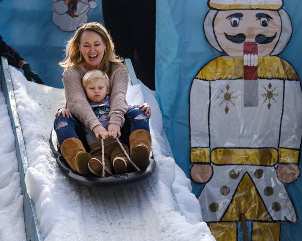 Anna Lonetti takes a ride on the snow with her 2-year-old grandson, Liam Olds, during the Candy Caneland and Craft Faire in Buena Park on Saturday, December 4, 2021. (Photo by Mindy Schauer, Orange County Register/SCNG)