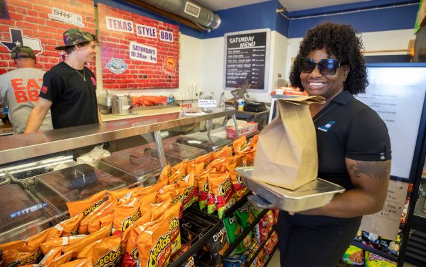 Some of OC's best bbq can be found inside The Minute King liquor store where Jeff Hayes prepares Texas-style BBQ in Newport Beach. Customer Chante Lasane picks up a bunch of pork ribs and some beef brisket on Saturday, October 14, 2023. (Sam Gangwer, Contributing Photographer)