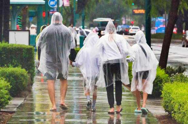 People brave the downpour from Tropical Storm Hilary as walk down Harbor Boulevard near the Disneyland Resort in Anaheim on Sunday, August 20, 2023. (Photo by Leonard Ortiz, Orange County Register/SCNG)