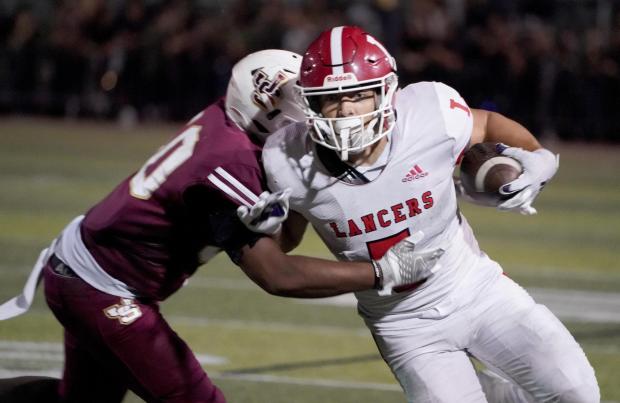 Orange Lutheran's Steve Chavez, right, rambles for more yards against the defense of JSerra High in the game between Orange Lutheran vs. JSerra in a Trinity League football game at JSerra in San Juan Capistrano, on Friday, September 29, 2023.. (Photo by Michael Kitada, Contributing Photographer)