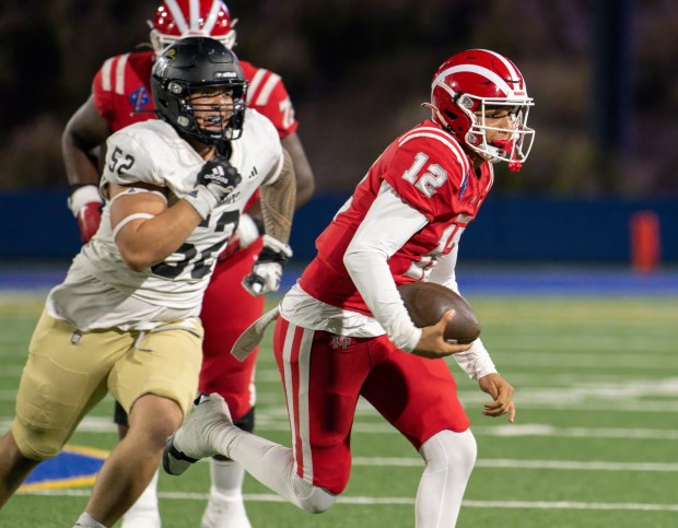 Mater Dei quarterback Elijah Brown, right, runs for big yardage on a keeper as he is chased by Servite defensive lineman James Campbell, left, in a Trinity League football game in Santa Ana on Friday, September 29, 2023. (Photo by Paul Rodriguez, Contributing Photographer)