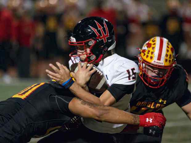 Palos Verdes quarterback Ryan Rakowski, center, is hit hard and brought down by Mission Viejo outside linebacker Jonavan Asuncion, left, in the first round of the CIF-SS Division 2 football playoff in Mission Viejo on Friday, November 3, 2023. (Photo by Paul Rodriguez, Contributing Photographer)