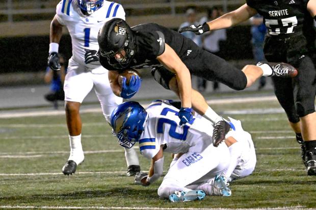 Aidan O'Callaghan (1) of Servite jumps over Logan Hirou (23) of Santa Margarita in a Trinity League football game at Cerritos College in Norwalk on Friday, October 20, 2023. (Photo by Leonard Ortiz, Orange County Register/SCNG)