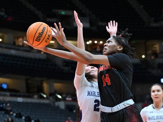 Orange Lutheran guard Princess Cassell, right, moves past Marlborough guard Lauren Munoz to score a basket in the CIF-SS Division 1 Championship basketball game in Anaheim on Saturday, February 25, 2023. (Photo by Paul Rodriguez, Contributing Photographer)