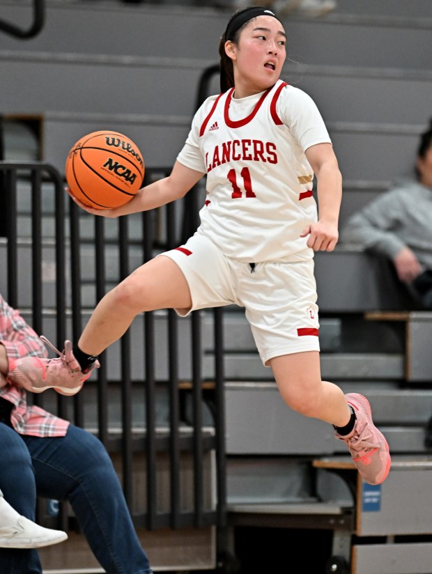 Orange Lutheran guard Shea Joko leaps to make a pass against Etiwanda during the second half of a CIF prep girls basketball game in the Troy Classic in Fullerton, Thursday, Dec. 8, 2022. (Photo by Alex Gallardo, Contributing Photographer)