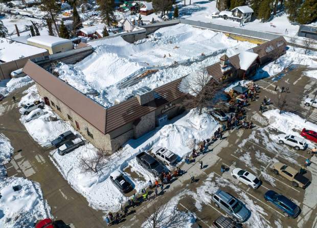 Despite a collapsed roof, people stand in line for food at Goodwin and Sons Market in Crestline, on Friday, March 3, 2023. (File photo by Jeff Gritchen, Orange County Register/SCNG)
