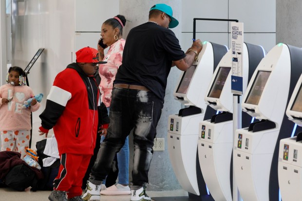 A passenger uses a self-service kiosk as a writing surface at Fort Lauderdale-Hollywood International Airport in Fort Lauderdale on Thursday, Nov. 2, 2023. (Amy Beth Bennett / South Florida Sun Sentinel)